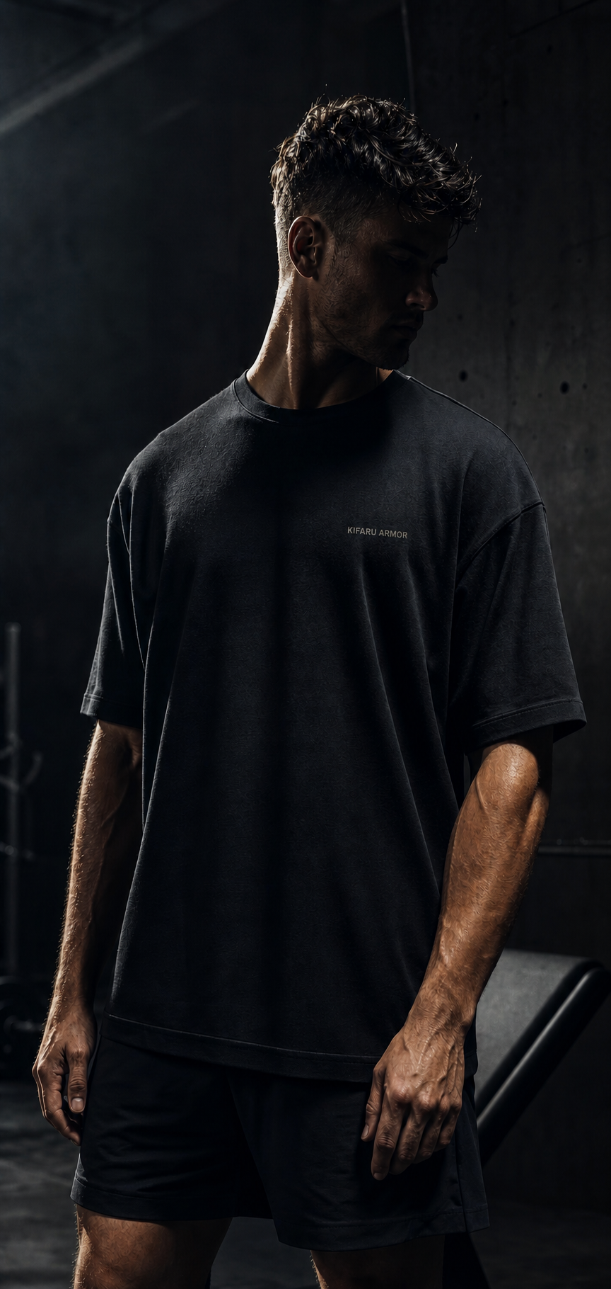 Atleta usando camiseta preta oversized em editorial fitness escuro